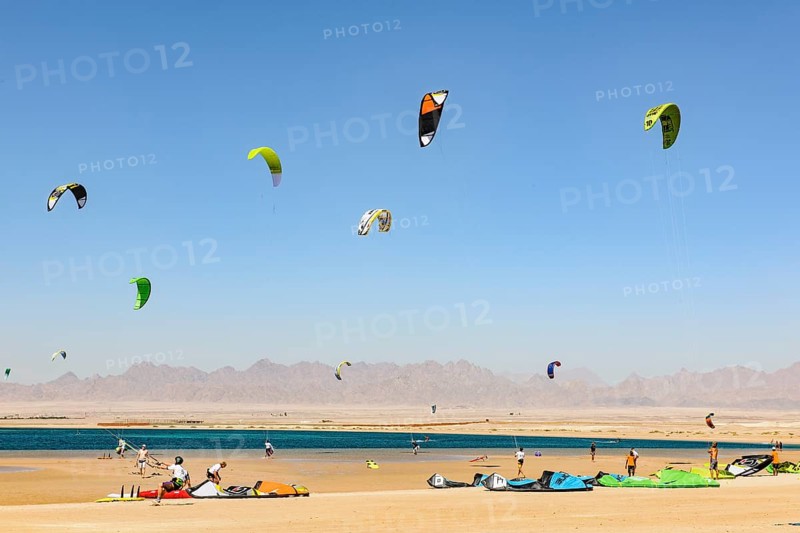 Sailing kitesurfers kite surfers kite surfers on the sea, many kite sails in the blue sky without clouds in the foreground discarded kite sails kite sails lying on sandy beach of Red Sea Bay, Soma Bay, Egypt, Africa
