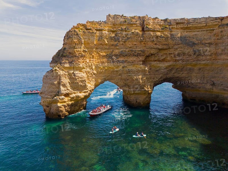 Large rock arch in the blue waters of the Algarve, Portugal, with several boats and tourists in the area, aerial view, Praia da Marinha, double rock arch, Lagoa, Rocky Algarve, Algarve, Portugal, Europe
