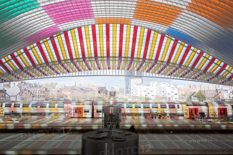 Liège-Guillemins railway station, architect Santiago Calatrava, colourful roof, trains, railway tracks with two people, high-rise buildings and other houses in the background, Liège, Belgium, Europe
