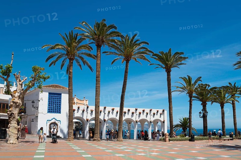 Sunny square with tall palm trees, white buildings and views of the sea under a clear blue sky, Plaza Balcon de Europa, Nerja, Málaga province, Malaga, Costa del Sol, Andalucia, Spain, Europe