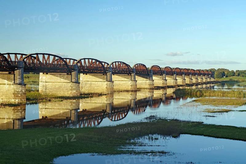 Long stone bridge with many arches crossing a calmly reflecting river, surrounded by nature, autumn, Elbe, Dömitzer railway bridge, Langendorf, Wendland, Lower Saxony, Germany, Europe
