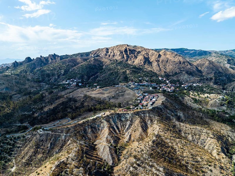 Mountains and Olive groves around Ghost Town from a drone, Pentedattilo Village, Calabria, Italy, Europe