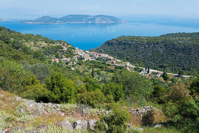 Coastal landscape with a village surrounded by green hills and the blue sea in the background, Palea Loutra, Methana, peninsula in the Argolis on the Saronic Gulf, Attica, Peloponnese, Greece, Europe