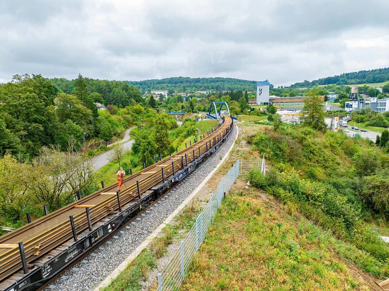 Train on railway line next to green countryside and city view, track construction, rail delivery for Hermann Hessebahn, Calw, Black Forest, Germany, Europe