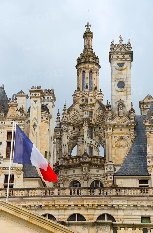 Detailed view of a historic castle with elaborate decorations and a French flag in the foreground, Chambord Castle, Château de Chambord, Loire Castle, Loire Valley, Loir-et-Cher Department, Centre Region, France, Europe