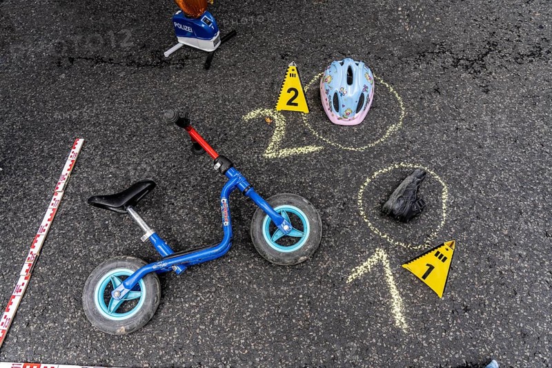Markings at an accident scene with a balance bike for children, helmet, reenacted accident recording, at a public event organised by the Cologne police, symbolic image