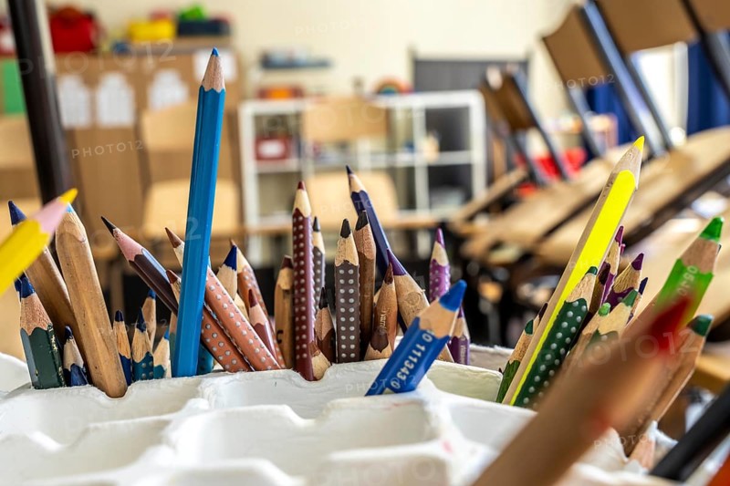Classroom of a fourth grade, after school, the building is older but in good condition, coloured pencils
