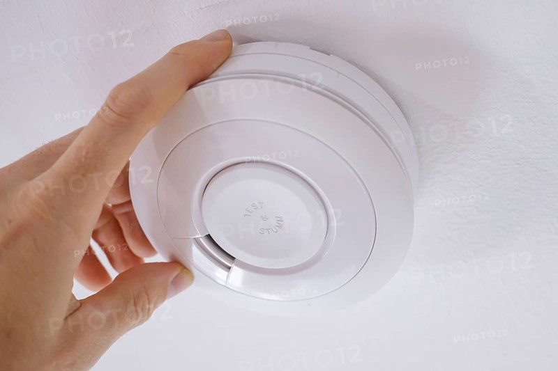 Symbolic photo on the subject of smoke alarms. A smoke detector hanging from the ceiling in a flat. Berlin, 21.08.2024