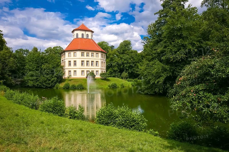 Oppenweiler moated castle, built in the 18th century, classicist style, castle complex in unequal-sided octagon, today town hall, architecture, tent roof with pavilion top, windows, lake, castle lake, water features, island, park, garden designer Friedrich Ludwig von Sckell, meadow, lawn, trees, bushes, shrubs, cloudy sky, Oppenweiler, Rems-Murr district, Baden-Württemberg, Germany, Europe