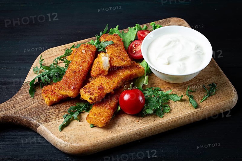 Fried fish nuggets, with white sauce, arugula and cherry, no people