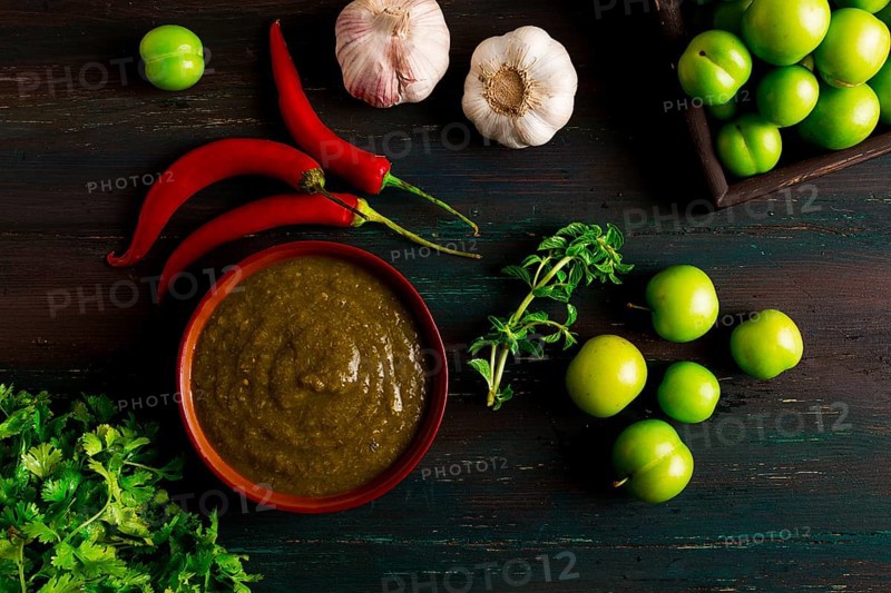 Tkemali sauce, traditional Georgian cuisine, green cherry plum, with ingredients for sauce, cilantro, mint, hot pepper, garlic, on a wooden table, close-up, rustic, food background, no people, selective focus, sauce, green sauce, tkemali, georgian cuisine, homemade