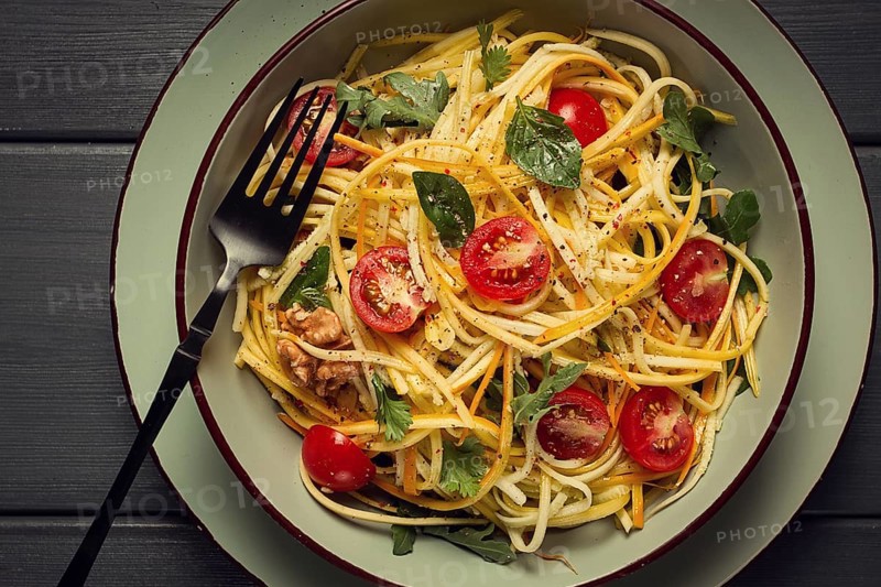 Yellow zucchini salad, with cherry, vegetarian food, sliced into strips, homemade