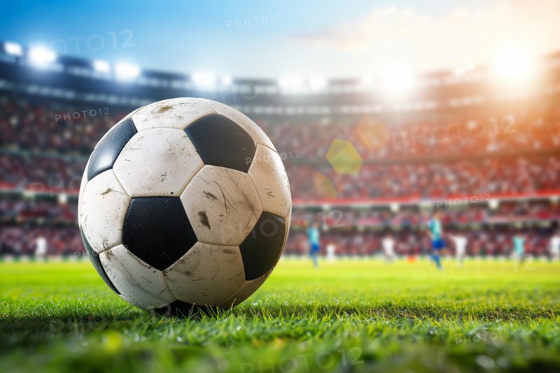 A soccer ball on a green field in soccer football stadium in evening on sunset with floodlights lights during game, AI generated
