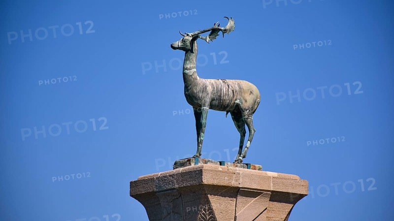 Bronze deer statue on a pedestal in front of a clear blue sky, Mandraki harbour, harbour area, Rhodes town, Rhodes, Dodecanese, Greek Islands, Greece, Europe