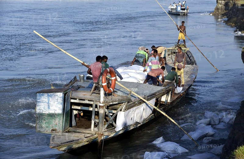 Public Works Department (PWD) of Assam labourer throwing sand bag from boat in the banks of Beki River to reduce soil erosion in Barpeta, Assam in India on Tuesday, November 13, 2018. The soil erosion of Beki river has become a major problem of flowing two districts Barpeta and Baksa of Assam