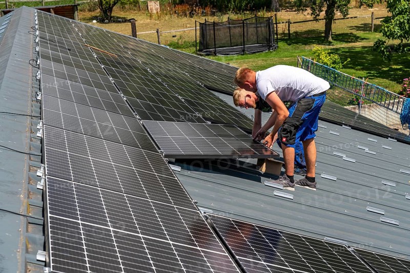 Installation of solar modules on the roof of a barn on a farm, over 210 photovoltaic modules are installed on the roof, North Rhine-Westphalia, Germany, Europe