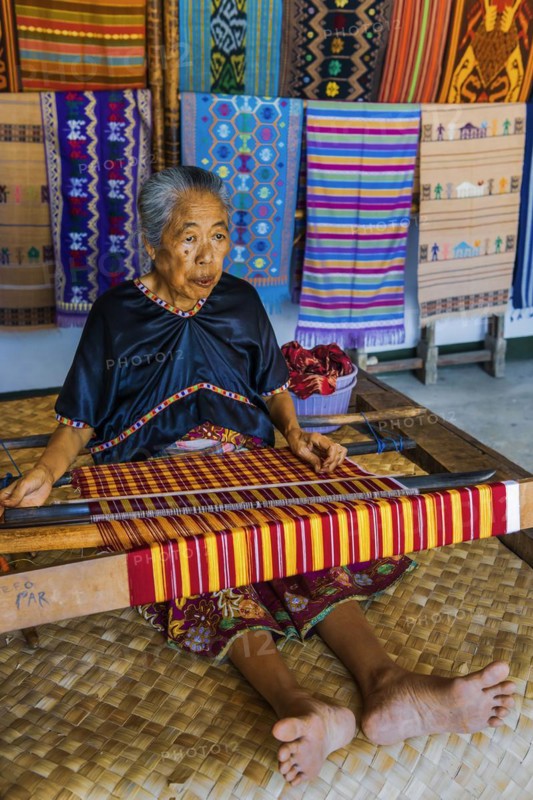 Traditional weaver, weaving, woman's work, working conditions, loom, textile, woman, trade, bazaar, authentic, fabric, fabric pattern, craft, handicraft, Asian, indigenous, tradition, traditional, marketplace, travel, tourism, culture, poverty, presentation, lifestyle, person, Muslim, Islam, Sasak, indigenous, indigenous people, cultural heritage, silk weaving, Sade village, Lombok, Indonesia, Asia