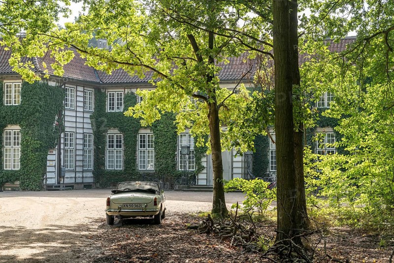 Vintage car parked in front of a historic, ivy-covered stately building surrounded by trees in the sunlight, Ordrupgaard Art Museum, Collection of Henny and Wilhelm Hansen, Ordrup, Charlottenlund, near Copenhagen, Denmark, Europe