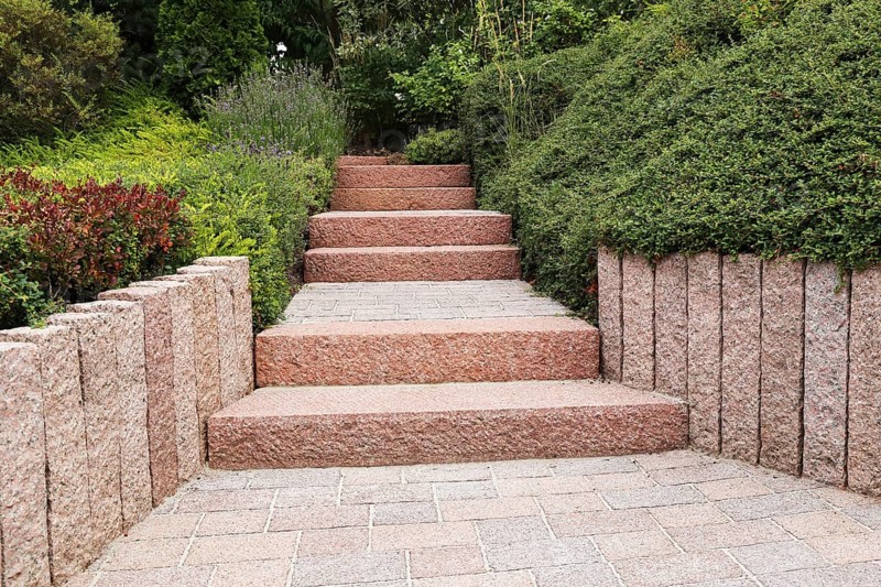 Well-kept front garden with block steps, ornamental stones and planting