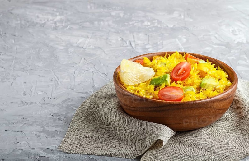 Fried pomelo with tomatoes and avocado in wooden plate on gray concrete background. side view, copy space, myanmar food