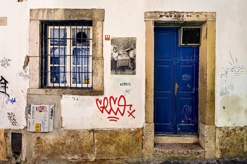 Graffiti and street art on weathered walls of an old building at nighttime, Alfama, Lisbon