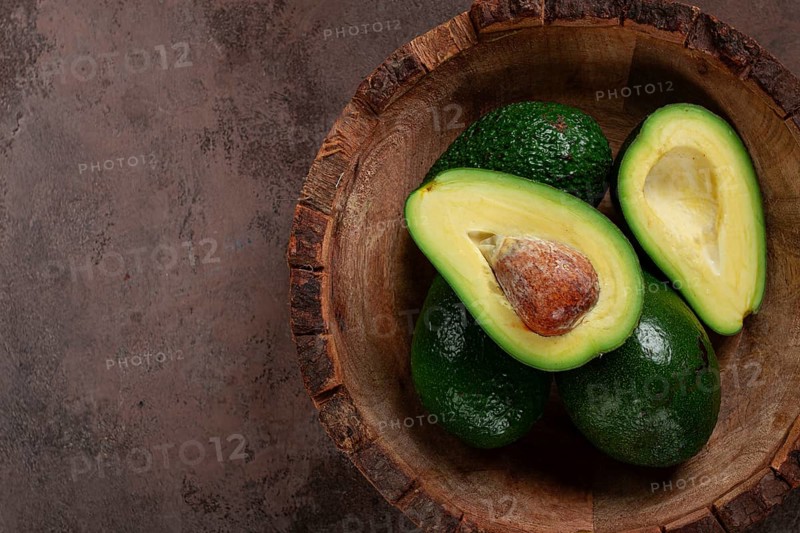 Fresh, sliced avocado, in a wooden plate, top view, food background, concept, food styling