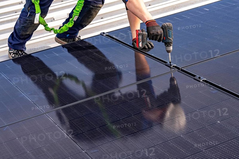 Installation of solar modules on the roof of a commercial enterprise, over 400 photovoltaic modules are installed on the roof, North Rhine-Westphalia, Germany, Europe