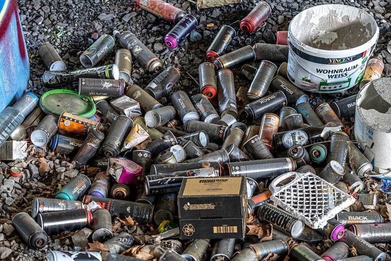 Empty spray paint cans, on a railway line below a road bridge, thrown away, disposed of by the sprayer, graffiti, rubbish heap, Essen, North Rhine-Westphalia, Germany, Europe