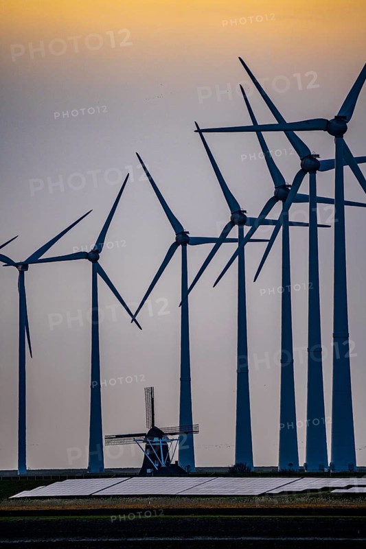Windmill Poldermolen De Goliath stands between the high-tech wind turbines in Eemshaven, historic windmill from around 1882, rebuilt and reconstructed several times, Westereems wind farm, solar farm on sea dike, Slaperdijk, a good 5 kilometres long, Netherlands