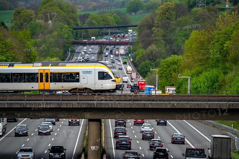 Eurobahn, regional train crossing the motorway A3, traffic on 8 lanes, incl. the temporarily released hard shoulder, behind the motorway junction Hilden, view in north direction, near Erkrath, North Rhine-Westphalia, Germany, Europe