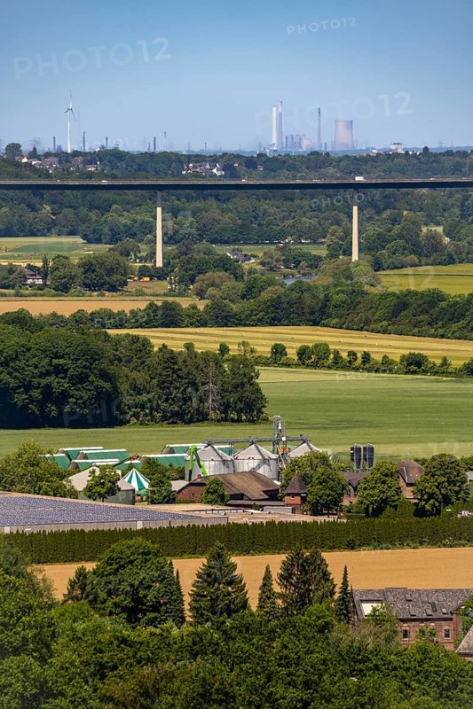 The Ruhr valley between Essen-Kettwig and Mülheim-Mintard, view to the west, Ruhr valley bridge of the A52 motorway, industrial backdrop of Duisburg, in the middle the decommissioned Voerde coal-fired power station, in front a biogas plant on a farm in Kettwig, North Rhine-Westphalia, Germany, Europe