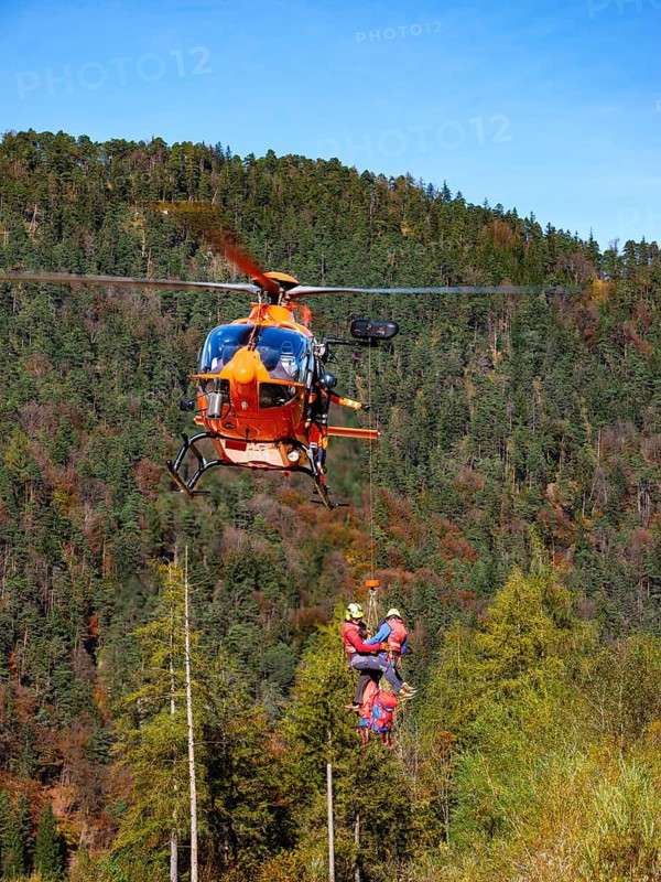 2 mountain rescuers of the Bavarian Mountain Rescue Service are winched by the on-board mechanic of the rescue helicopter Christoph 14 with the cable winch, Bad Reichenhall, Berchtesgadener Land, Upper Bavaria, Bavaria, Germany, Europe