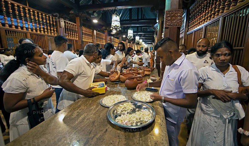Sri Lankan pilgrims offering white jasmine flowers at the Buddhist Temple of the Tooth or Sri Dalada Maligawa, Kandy, Central Province, Sri Lanka, Asia
