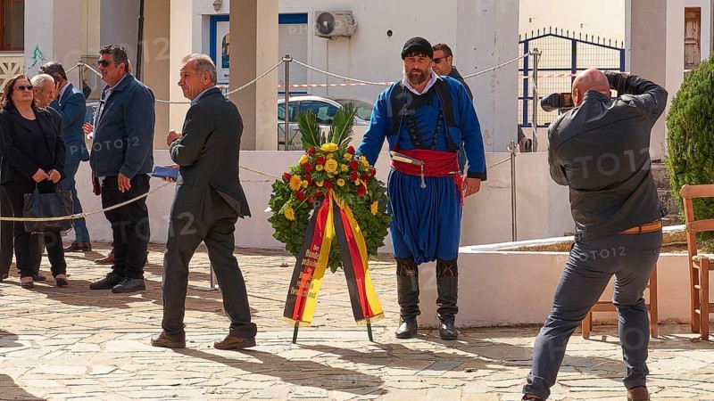 A man in traditional Cretan traditional costume carries a wreath at a ceremony, photographed by a photographer, visit of German President Frank-Walter Steinmeier to Kandanos on 31 October 2024, German President, Frank-Walter Steinmeier, memorial, war crimes, Nazis, Wehrmacht crimes, World War II, Kandanos, Southwest Crete, Crete, Greek Islands, Greece, Europe