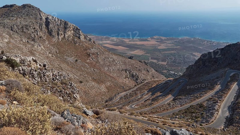 Panorama of a winding road that stretches through hilly terrain to the coast and the blue sea, Winding road along the Kallikratis Gorge, Lefka Ori, White Mountains, Mountain massif, West, Crete, Greece, Europe