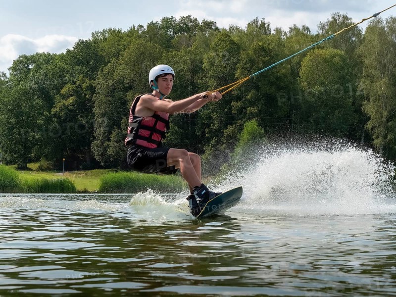 Young man on wakeboard in splashing water, water skiing and wakepark, water sports, Stráž pod Ralskem, Czech Republic, Europe