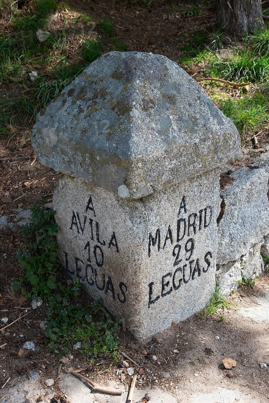 An old stone milestone with inscriptions shows the distance to Avila and Madrid, old stone signal, distance in leagues, old Roman route, at the Puerto del Pico, Sierra de Gredos, Ávila, Avila, Castilla y León, Leon, Spain, Europe
