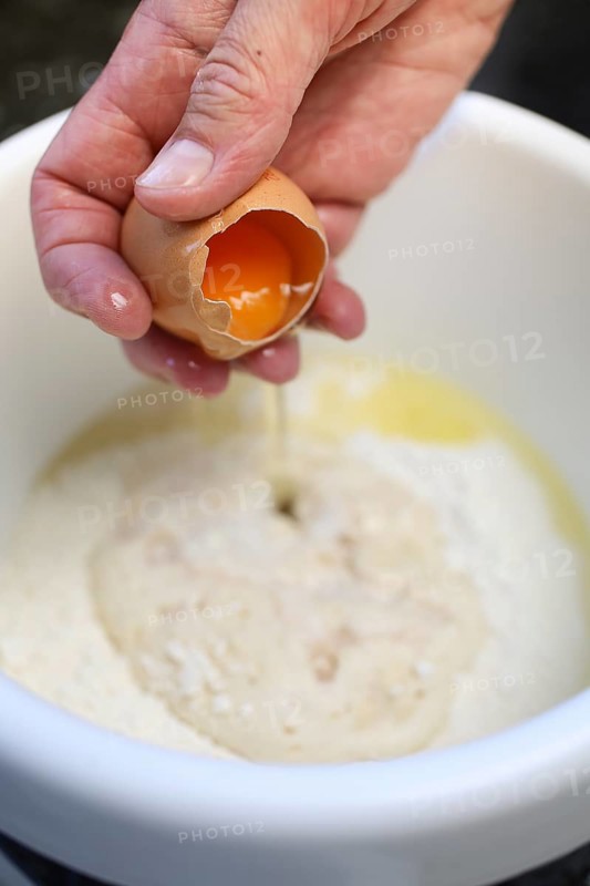 Swabian cuisine, add raw egg to yeast yeast dough, preparation of broad beans with yeast dumplings, broad beans, savoury, salty, typical Swabian, home cooking, traditional cuisine, mixing bowl, men's hands, food photography, studio, Germany, Europe