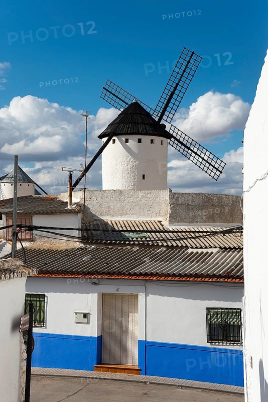 White and blue house and windmill under a sunny sky in a rustic village, Campo de Criptana, Ciudad Real province, Castilla-La Mancha, Don Quixote Route, Spain, Europe