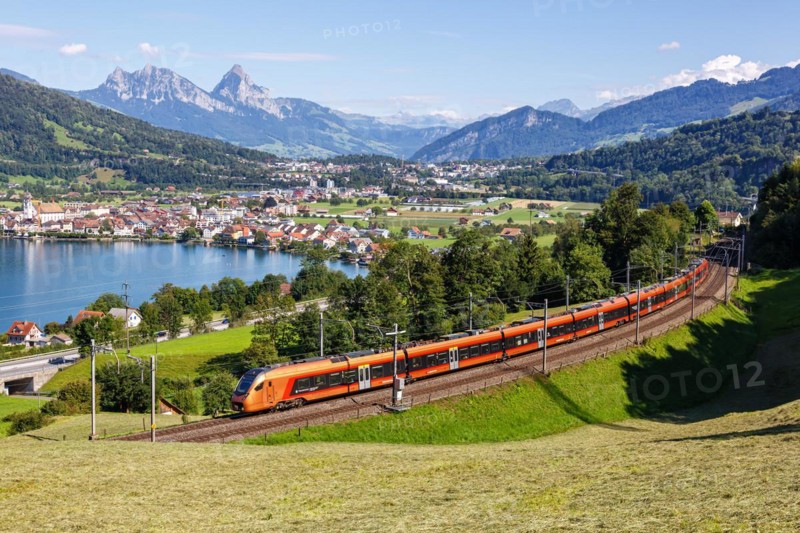 Railway passenger train of the type Stadler Flirt of the Südostbahn on the mountain Großer Mythen at Lake Zug in the Alps in Arth, Switzerland, Europe