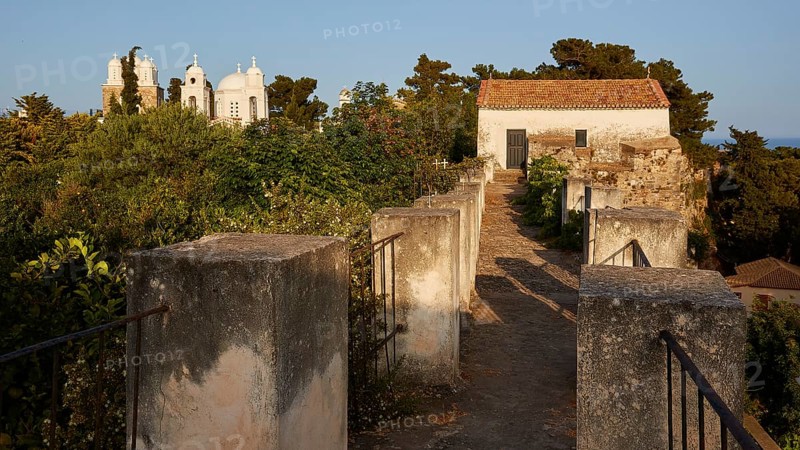 View through old walls to a church surrounded by trees in the soft evening light, Koroni, Byzantine fortress, nunnery, Peloponnese, Greece, Europe