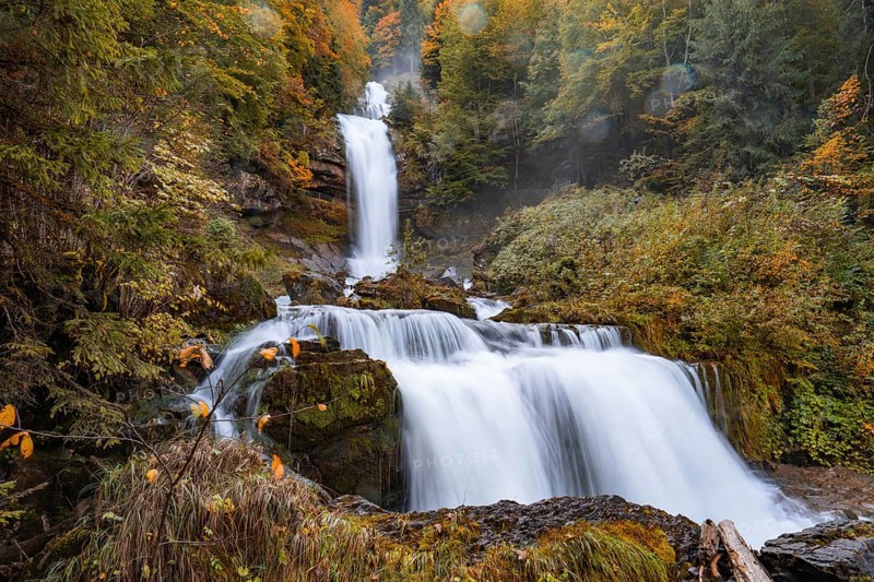 A picturesque autumn waterfall surrounded by colourful trees and lush nature, Giesbach Waterfalls, Lake Brienz, Switzerland, Europe