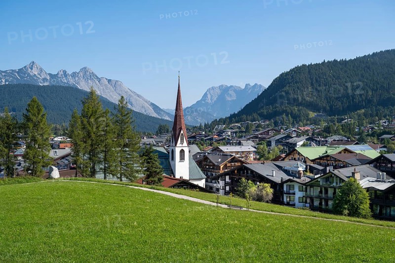 View of the village with St Oswald parish church, Karwendel mountains, view from the parish hill, Seefeld, Tyrol, Austria, Europe