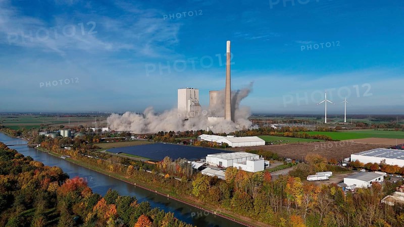 A power plant is being demolished, smoke rises, wind turbines stand next to it in an autumn landscape, blasting of the ash silos, Mehrum coal-fired power plant, Peine district, Lower Saxony, Germany, Europe