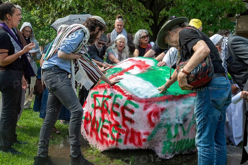 Detroit, Michigan USA, 15 July 2024, Interfaith leaders gathered at Wayne State University to rally and pray for peace in Gaza. They asked that the university divest from companies that profit from war and weapons manufacturing. The university turned on lawn sprinklers all around 'Spirit Rock, ' where they planned to gather. Spirit Rock was the site of a student anti-war encampment that university police broke up in May