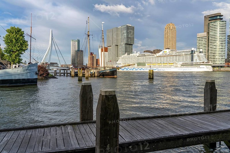 Rotterdam, skyline at the Nieuwe Maas, Erasmus Bridge, skyscrapers at the Kop van Zuid district, cruise ship Aida Prima at the Cruise Terminal, Veerhaven, historic ships, sailing boats, pier, Netherlands
