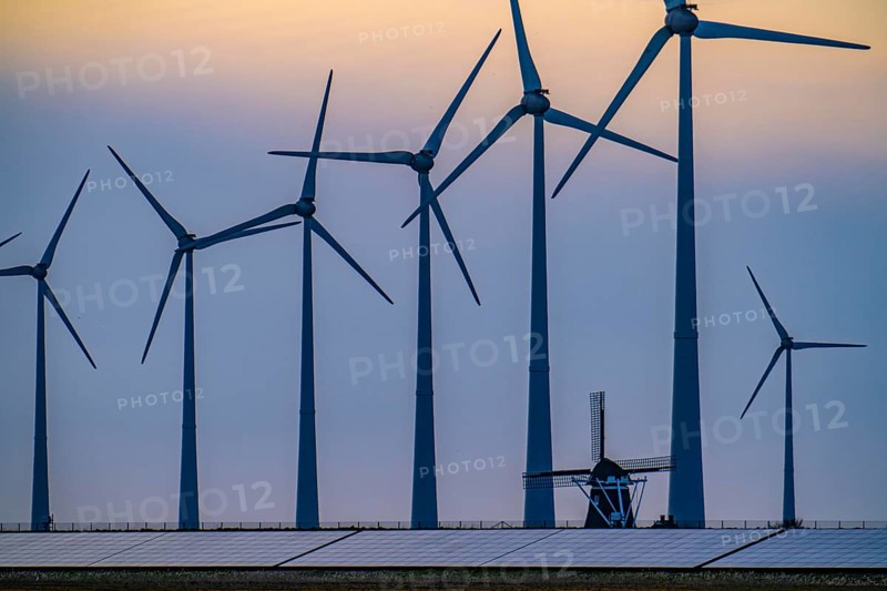 Windmill Poldermolen De Goliath stands between the high-tech wind turbines in Eemshaven, historic windmill from around 1882, rebuilt and reconstructed several times, Westereems wind farm, solar farm on sea dike, Slaperdijk, a good 5 kilometres long, Netherlands
