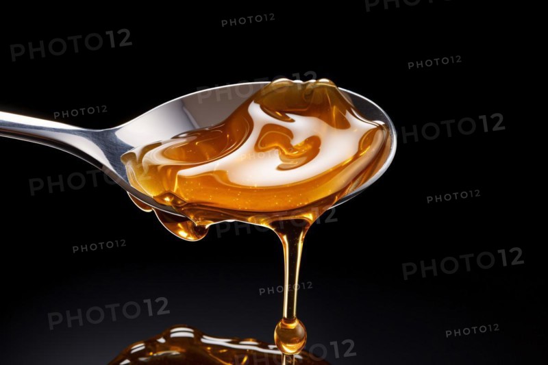 Honey dipping from spoon on black background. KI generiert, generiert, AI generated