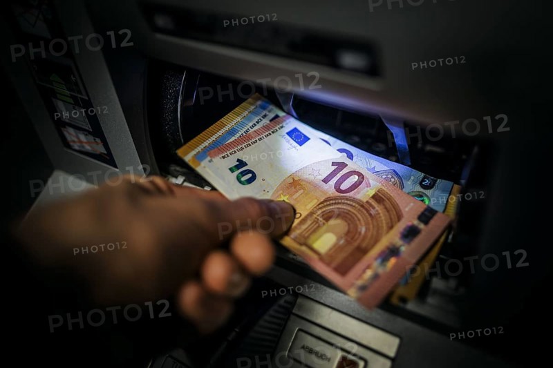 Symbol photo on the subject of withdrawing money from an ATM. Banknotes being withdrawn from an ATM. Berlin, 08.05.2024