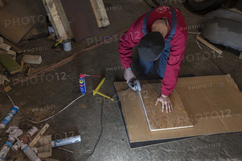 Young man working with an angle grinder in his workshop, Mecklenburg-Western Pomerania, Germany, Europe